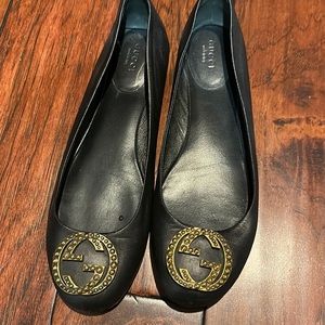 Black leather gucci ballet flats wit gold interlocking Gs.